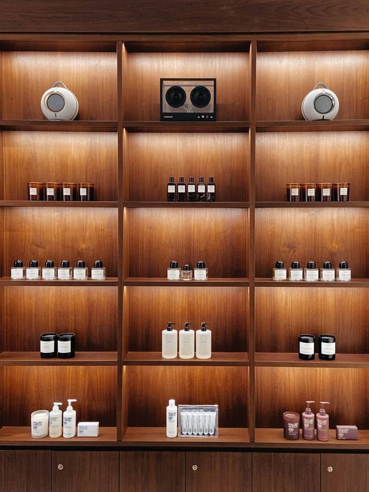 Lit walnut shelving holding bottles and jars